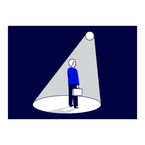 Une personne seule, de dos, dans le faisceau lumineux d'un projecteur.